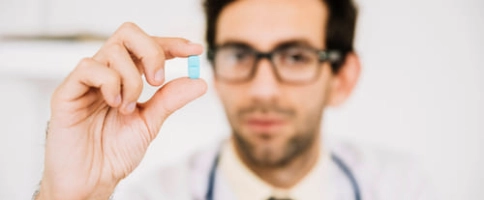 врач держит в руке таблетку от запоя 